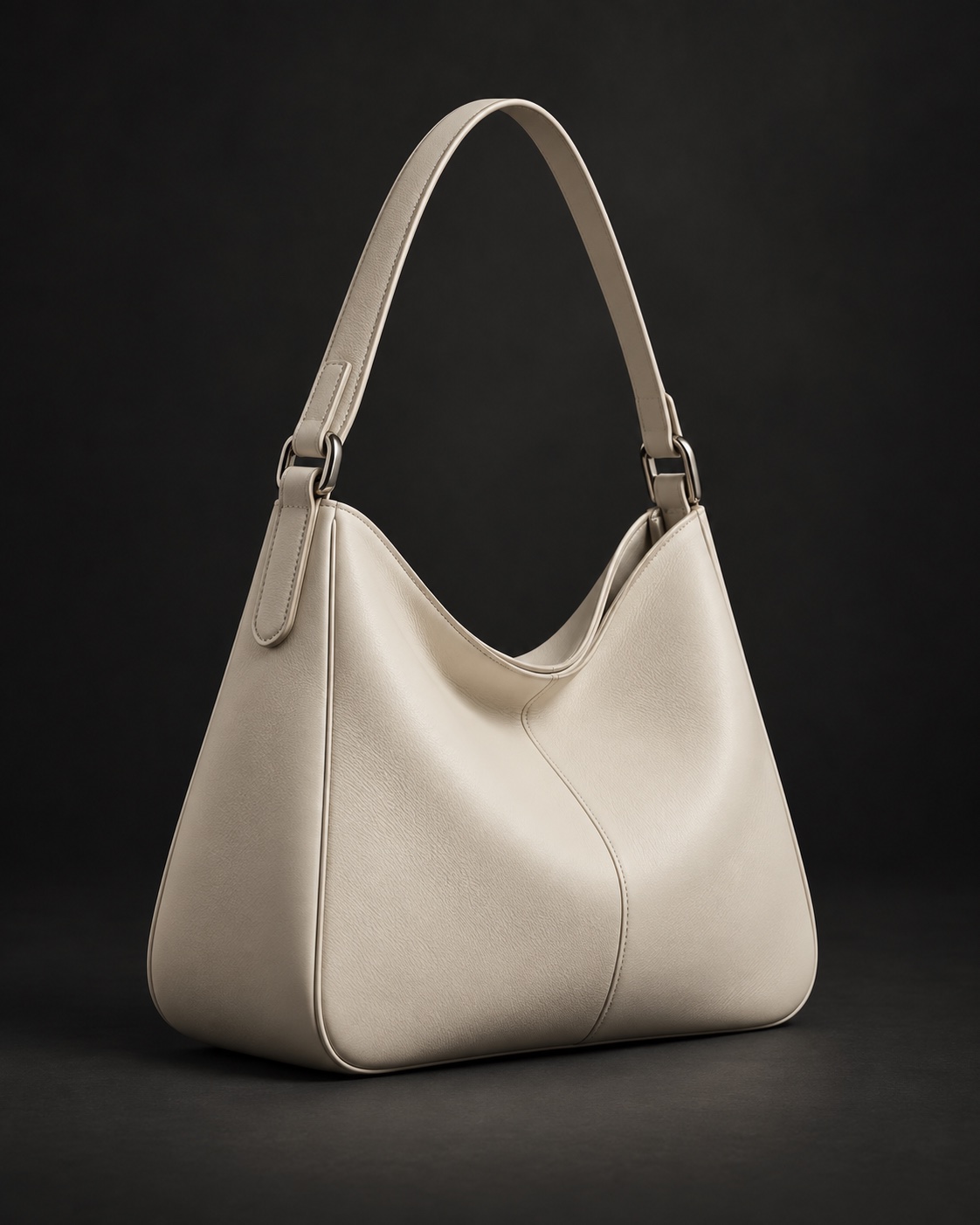 Warm ivory leather shoulder bag on a charcoal studio background